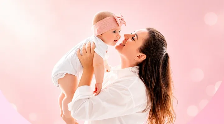A mother lifting her smiling baby